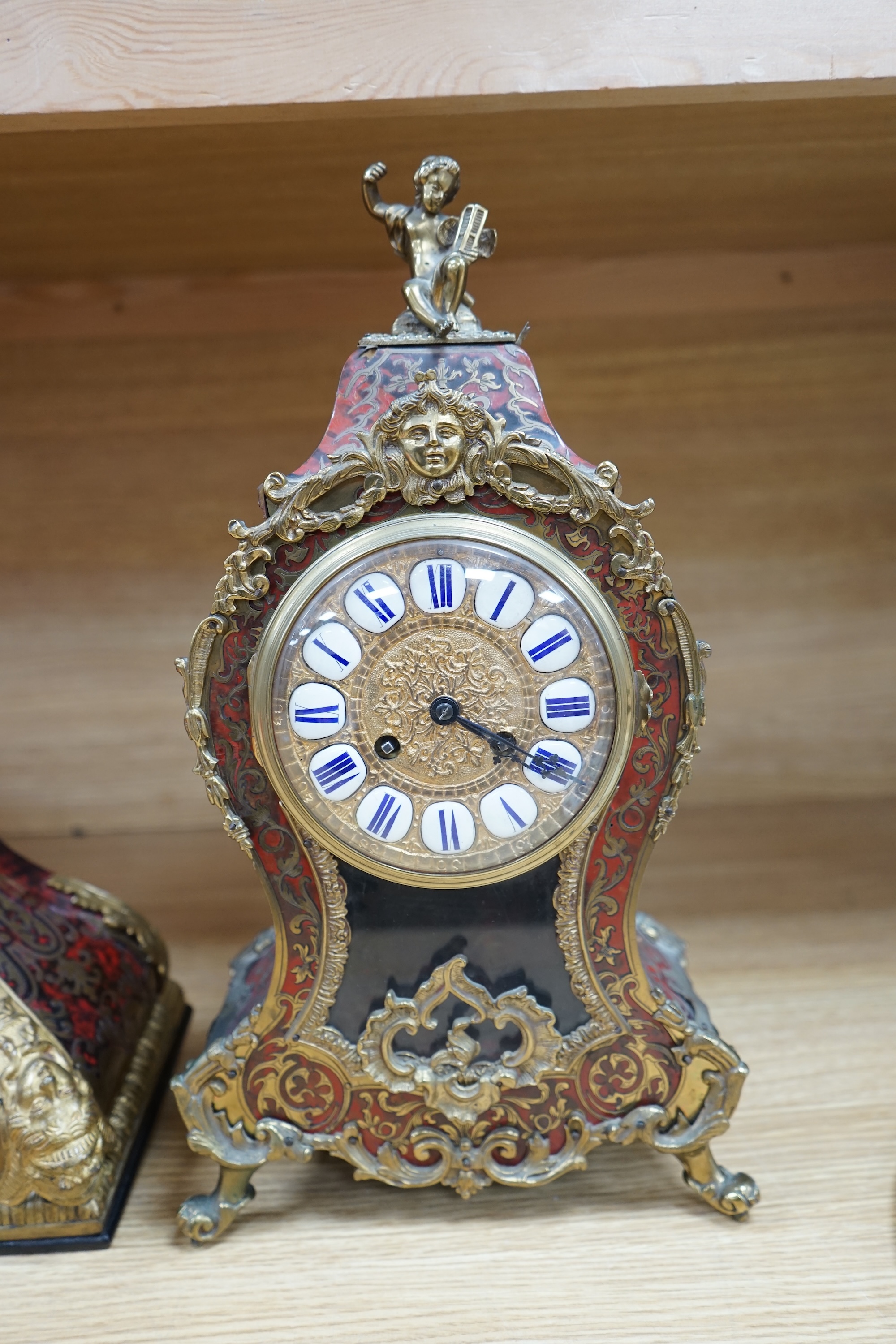 A French scarlet Boulle clock, and original bracket, the waisted case with glass front enclosing boulle interior and sunburst pendulum, c. 1860, clock 42cm high. Condition - fair, untested